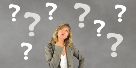 Stock image of a woman thinking surrounded by large question marks